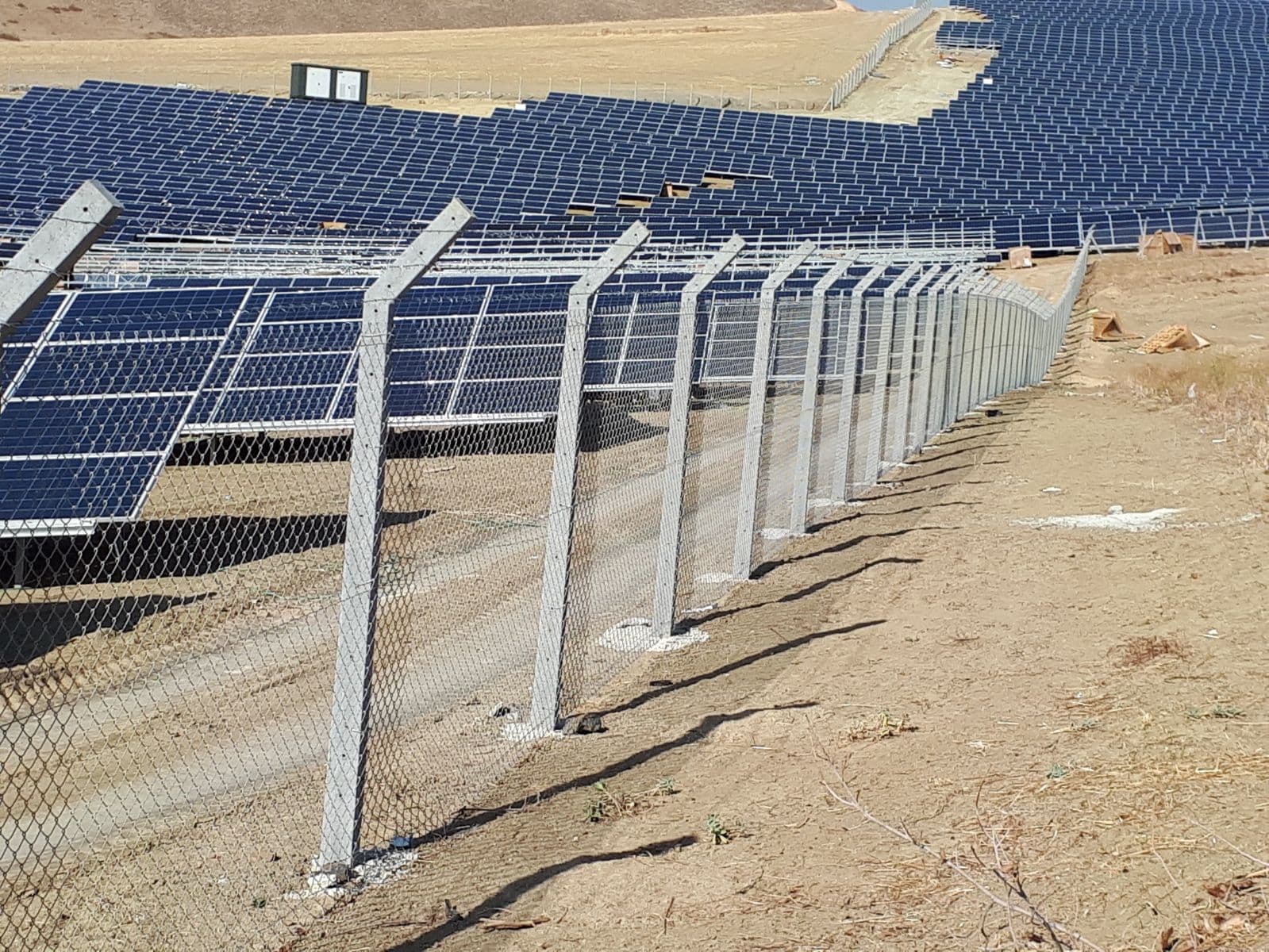 Güneş enerjisi santrali sahasının uzun beton direkli örgü tel çevre hattı